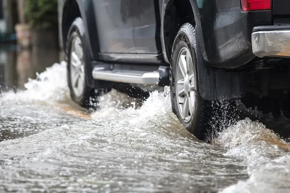 coche circulando por pavimento inundado