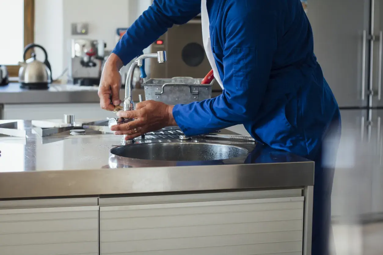 profesional reparando grifo de la cocina