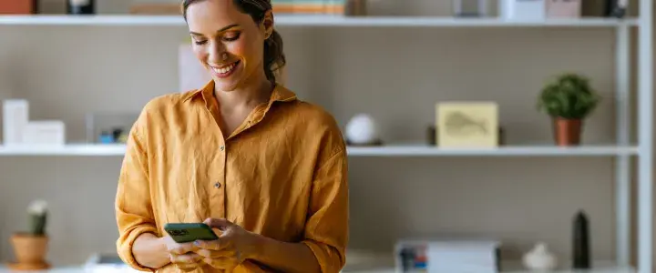 mujer viendo su móvil sonriendo