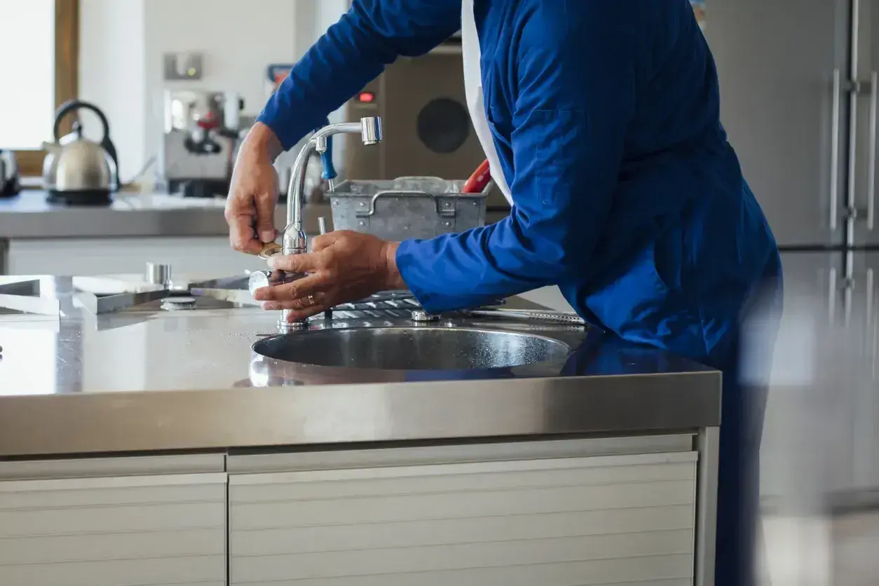 fontanero arreglando grifo de cocina